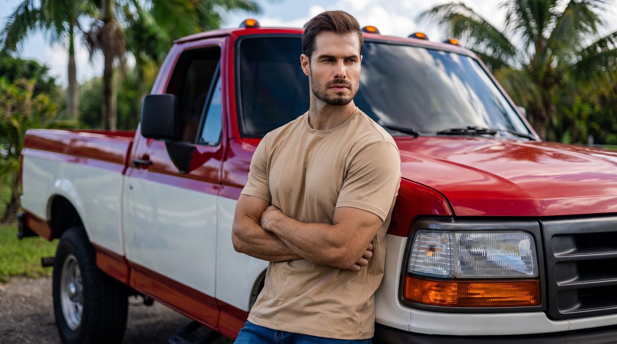 Homem de verde-militar num muscle car vermelho